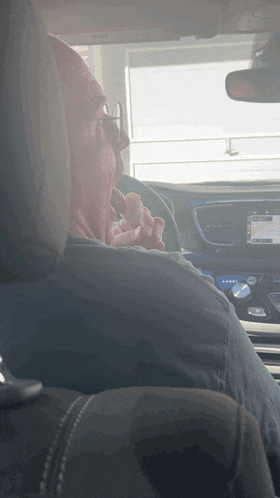 a man smoking a cigarette while sitting in the driver 's seat