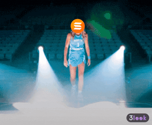 a woman in a north jersey stands on a stage in front of a spotlight