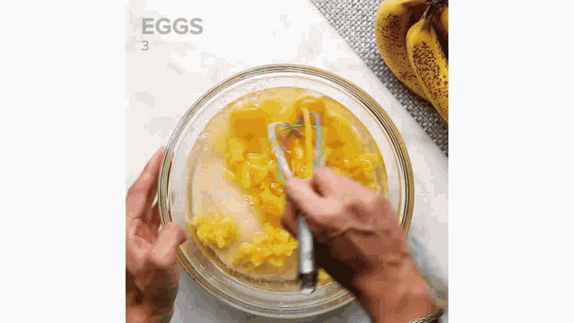 a person is whisking eggs in a bowl .