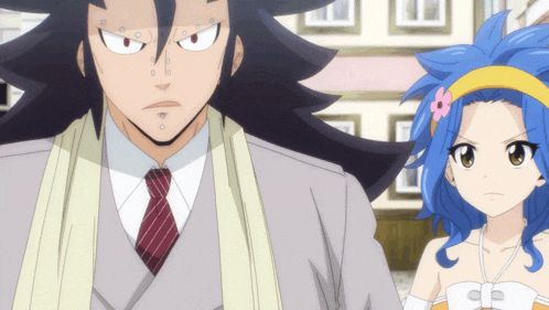 a man in a suit and tie and a girl with blue hair are standing next to each other