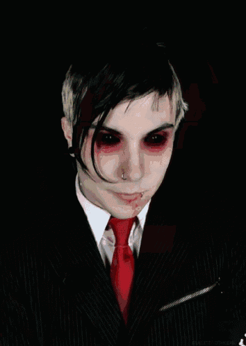a man in a suit and tie has blood on his eyes