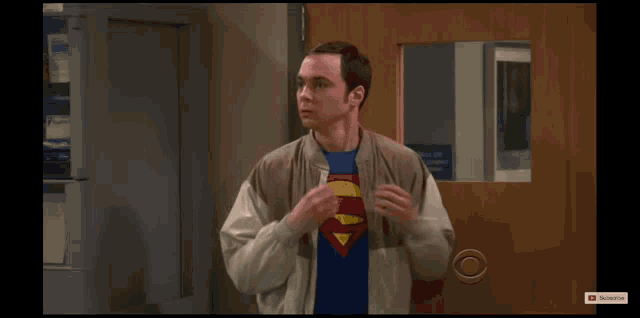a man wearing a superman tie is standing in front of a door that says subscribe