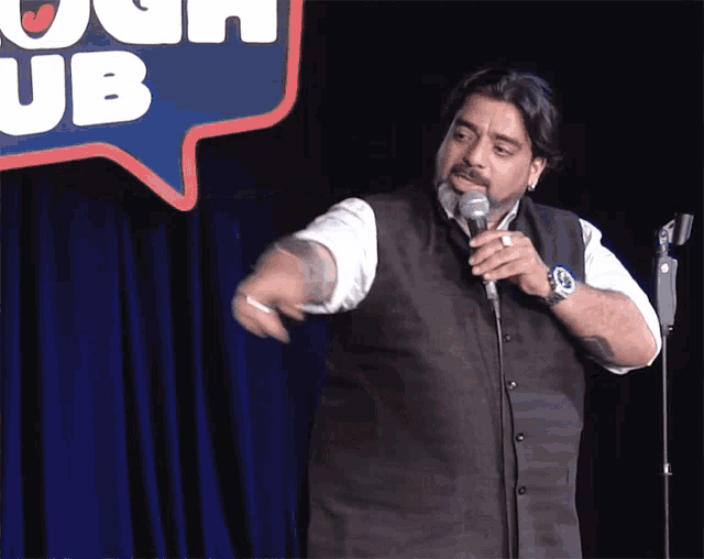 a man stands in front of a sign that says " laugh club "