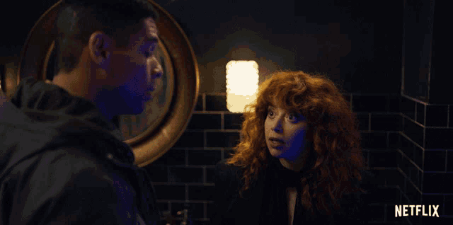 a man and a woman are standing in a dark room with a netflix logo in the corner