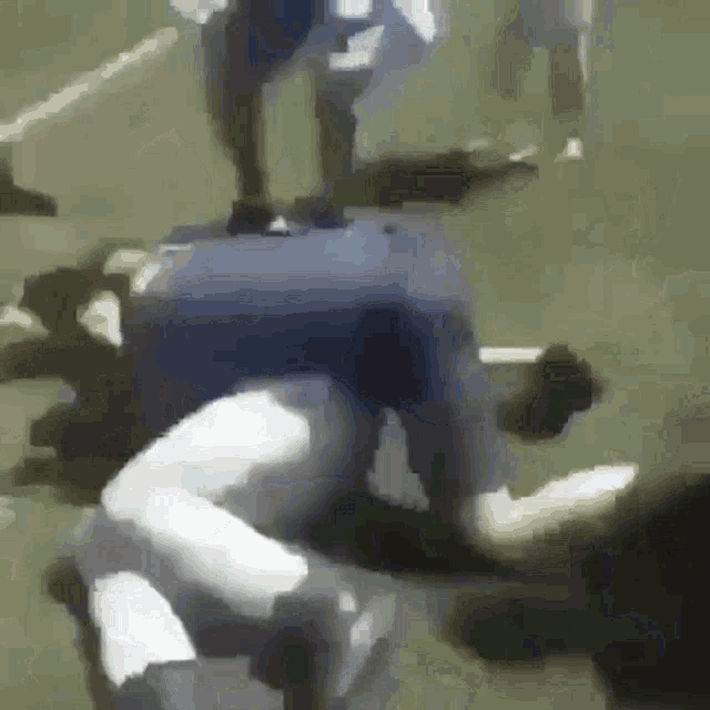 a blurry picture of a man laying on the ground with a blue shirt on .