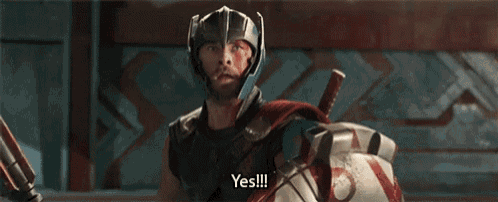 a man in a helmet is holding a shield and a hammer and says yes .