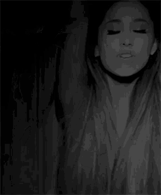 a black and white photo of a woman with her arms outstretched and her mouth open .