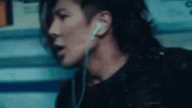 a man with a shaved head is wearing headphones .