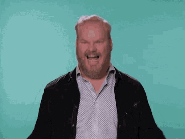 a man with a beard is laughing with his eyes closed