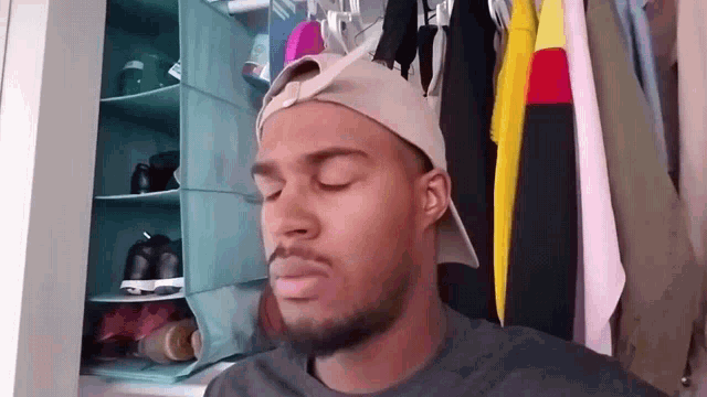 a man with his eyes closed wearing a hat
