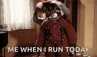a person in a red coat is standing in a room with the words `` me when i run today '' written on the screen .