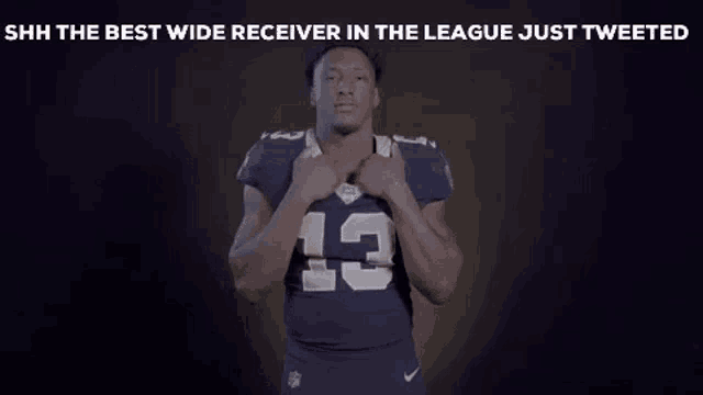a football player with the number 13 on his jersey is making a shhh gesture .