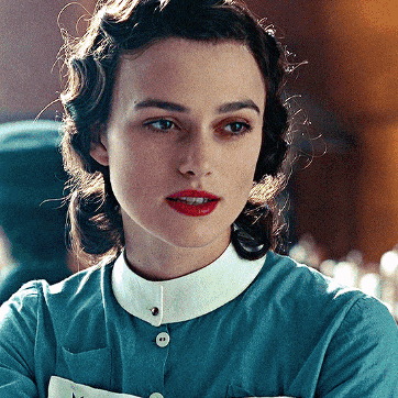 a close up of a woman 's face wearing a blue shirt