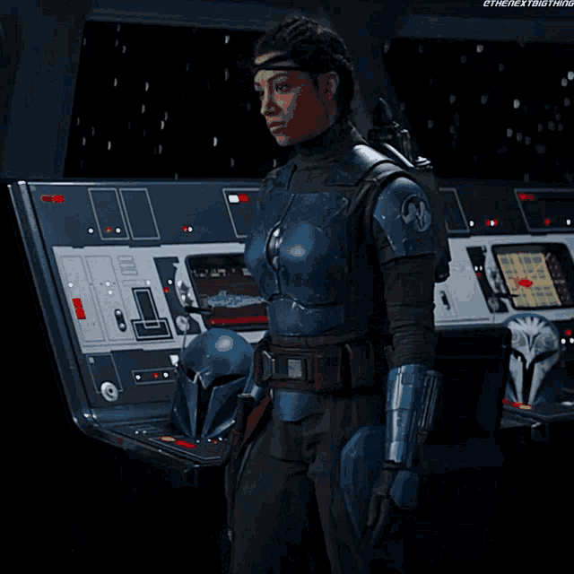 a woman in a blue armor stands in front of a control panel that says ' ethenextbigthing ' on it