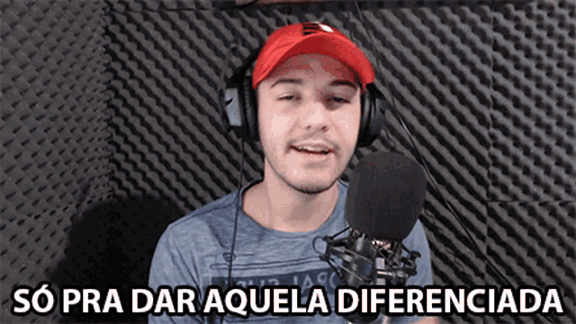 a man wearing headphones stands in front of a microphone with the words so pra dar aquela diferenciada above him