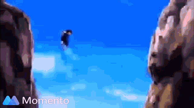 a person is flying through the air between two cliffs with the words momento in the corner