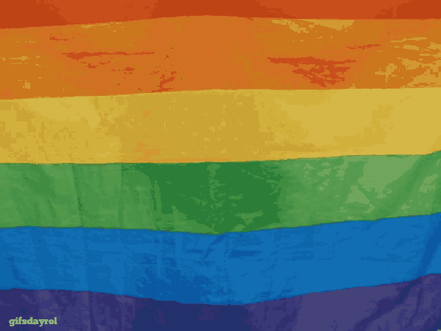 a close up of a rainbow flag with the words gifsdayrol on the bottom