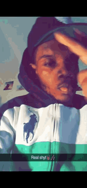 a man wearing a polo shirt and a hat is taking a selfie with a caption that says real shyt