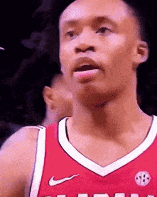 a basketball player wearing a red jersey with a sb logo on it