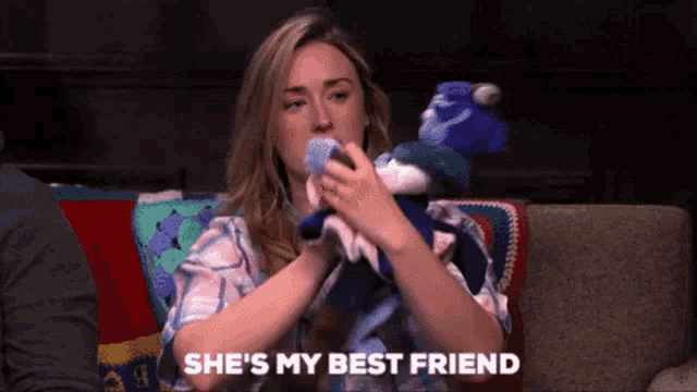 a woman is sitting on a couch holding a stuffed animal and says she 's my best friend .