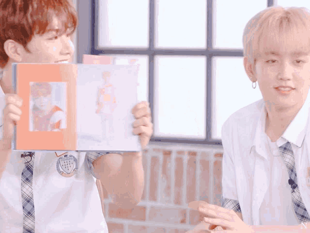a boy in a white shirt is holding a book with a picture of a man on it