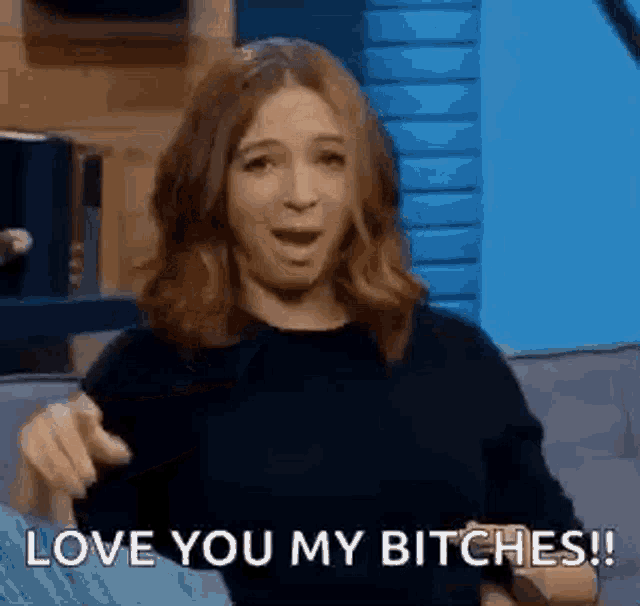 a woman is sitting on a couch with her mouth open and saying `` love you my bitches ! ''