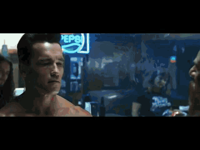 arnold schwarzenegger is standing in front of a pepsi sign