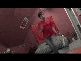 a man in a red shirt dancing in a room