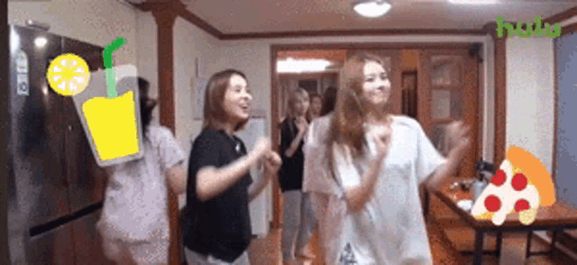 a group of women are dancing in a room with a pizza and a lemonade bottle on the wall