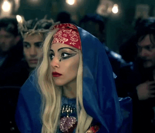 lady gaga is wearing a blue cape and a bandana on her head