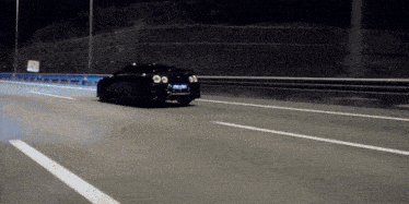 a black car is driving down a highway at night with a license plate that says ' a '