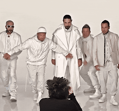 a group of men in white clothes are posing for a photo