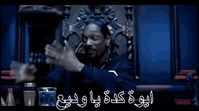 snoop dogg is sitting in a chair with his hands outstretched