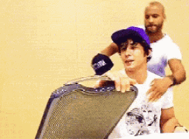 a man in a purple hat is sitting in a chair