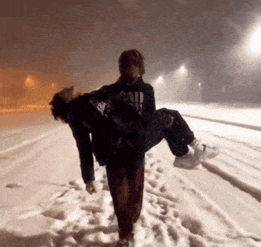 a person carrying another person in the snow with a sweatshirt that says cali