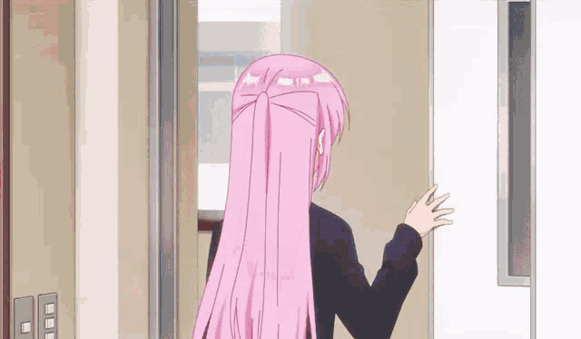 a girl with pink hair is standing in a doorway and waving .