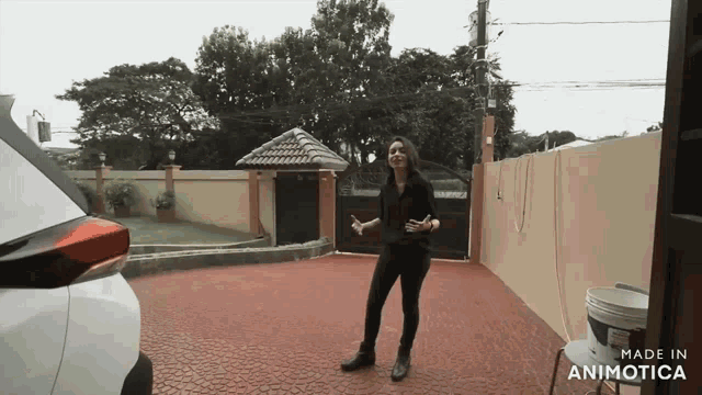 a woman is dancing in front of a white car with the words made in animotica on the bottom