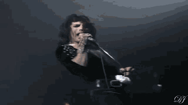 a man is singing into a microphone while holding a ball .