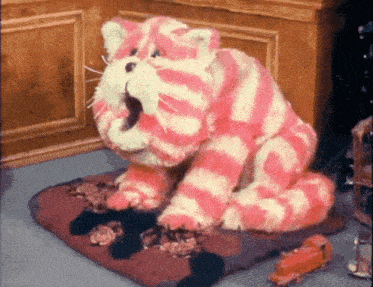 a pink and white cat is sitting on a pillow