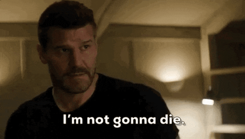 a man is standing in a dark room and saying `` i 'm not gonna die . ''