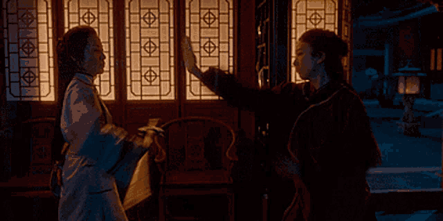 a woman in a dark room with a stained glass window