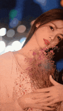 a woman in a pink dress is holding a bunch of flowers