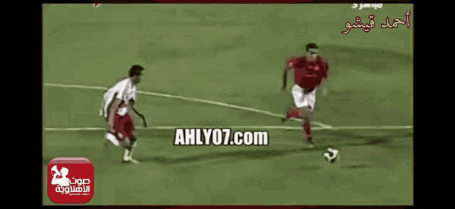 a group of soccer players on a field with the website ahlyo7.com