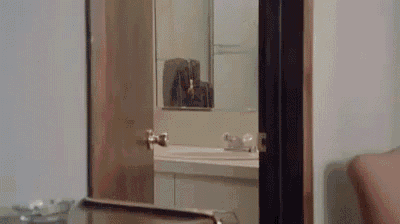 a bathroom with a sink , mirror , and a door open .