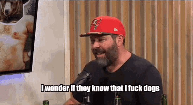 a man with a beard wearing a red hat says i wonder if they know that i fuck dogs
