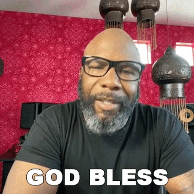 a bald man with glasses and a beard says " god bless "
