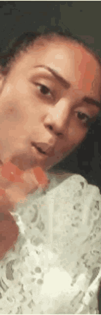 a close up of a woman 's face with a surprised look on her face while looking at the camera .