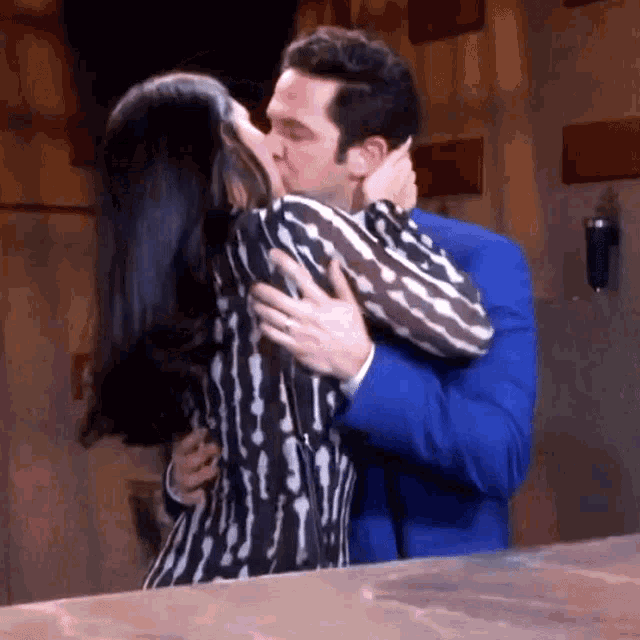 a man and a woman are kissing on a table .