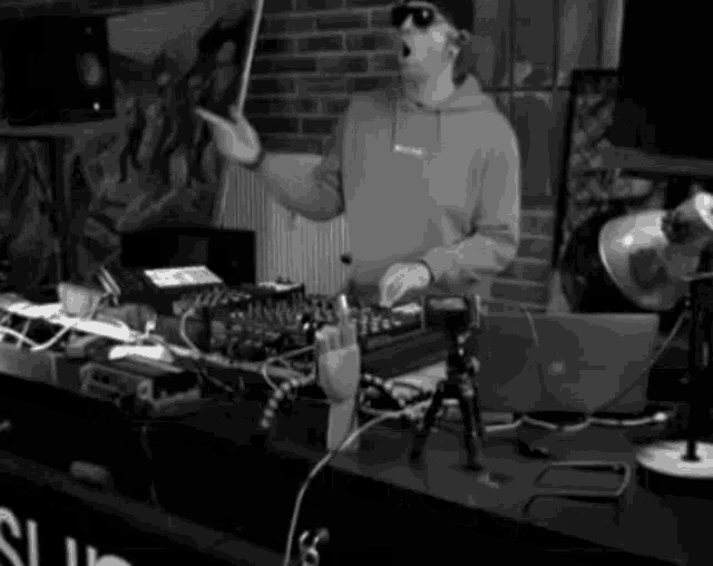 a black and white photo of a man standing in front of a mixer .