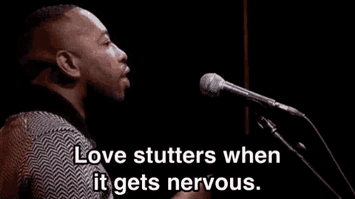 a man is singing into a microphone with the words love stutters when it gets nervous